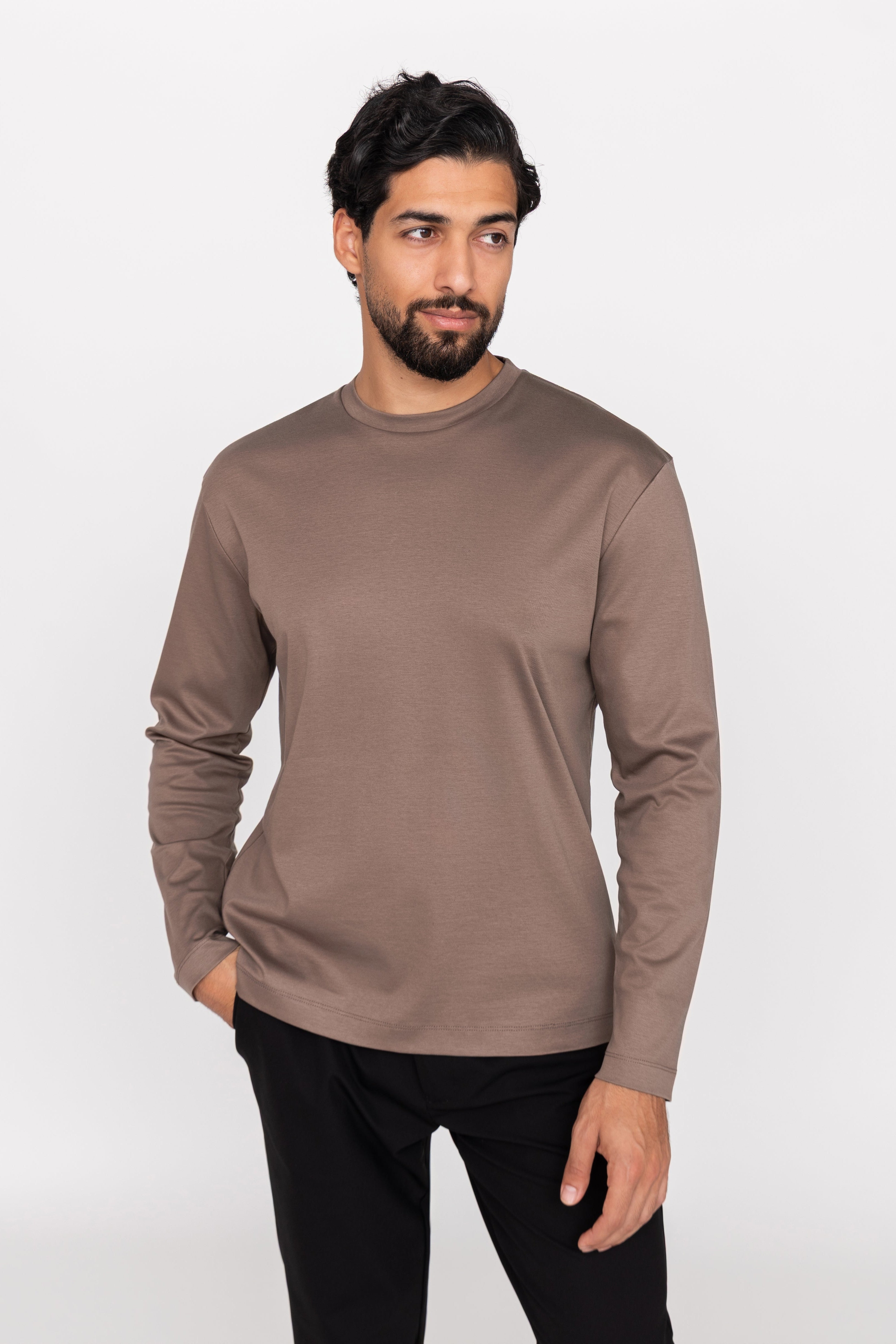 Man wearing a brown long-sleeve shirt against a white background